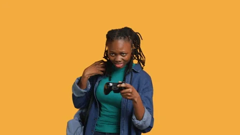 Gamer holds controller, focused on finishing videogame level, studio background Stock Footage 273833220