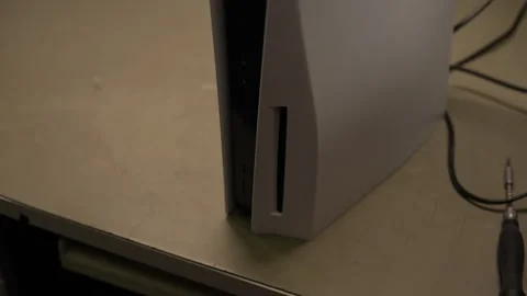 Gamer inserting game disk into modern white video game console, preparing for Stock Footage 306891094