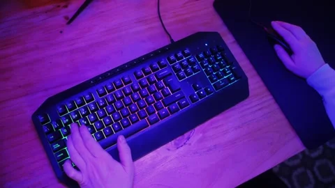 Gamer man typing on backlight keyboard close-up, man playing video game . Male Stock Footage 270099108