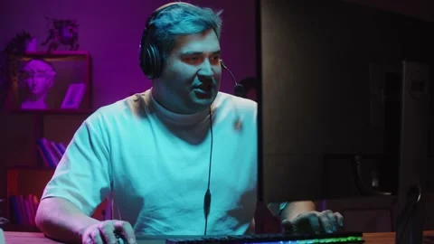 Gamer playing computer game, streamer wearing headphones. Young man playing Видео 180549289