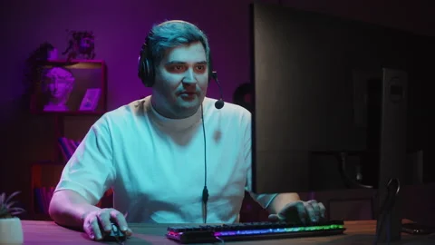 Gamer playing computer game, streamer wearing headphones. Young man playing Видео 180551566