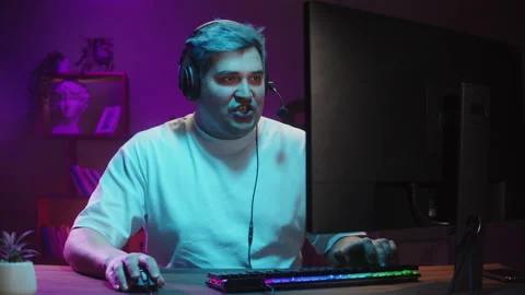 Gamer playing computer game, streamer wearing headphones. Young man playing Видео 180552443
