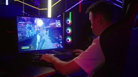 Gamer playing in an internet round of a fun battle royale shooter pc game Stock Footage 236258476