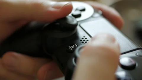Gamer playing on a PlayStation 4 controller gamepad macro close up Video stock 140607484