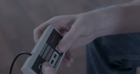Gamer plays with classic Nintendo controller Stock Footage 154483886
