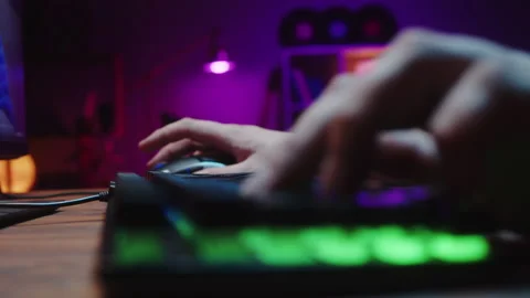 Gamer typing on backlight keyboard close-up, man playing video game. Male hands Stock Footage 171194493