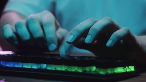 Gamer typing on backlight keyboard close-up, man playing video game. Male hands Stock Footage 171529622