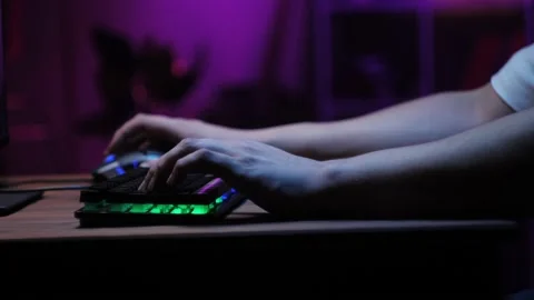 Gamer typing on backlight keyboard close-up, man playing video game. Male hands Stock Footage 195121911