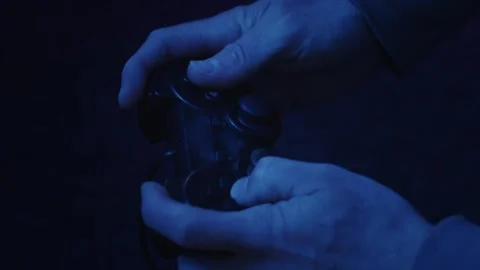 Gamer using a gaming controller fast and aggressively in subdued light Видео 241448252