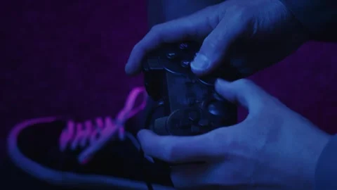 Gamer using a gaming controller fast and aggressively in subdued light Stock Footage 241448270