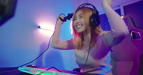 Gamer using joystick controller plays online video game with computer neon Stock Footage 219848985