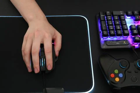 Gamer using modern wired computer mouse at dark table, above view Foto stock