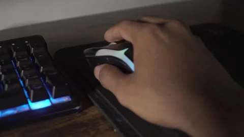 Gamer using rgb mouse and backlit keyboard Stock Footage 320967634