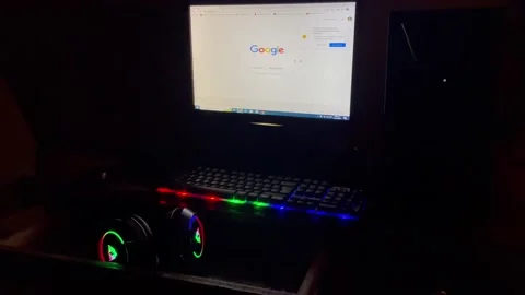 A gamer's computer for playing a video game with a neon keyboard and Headphone Stock Footage 235704301