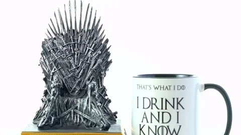 Games of Thrones HBO authorized replica of the Iron Throne with I Drink mug. Stock Footage 93880441