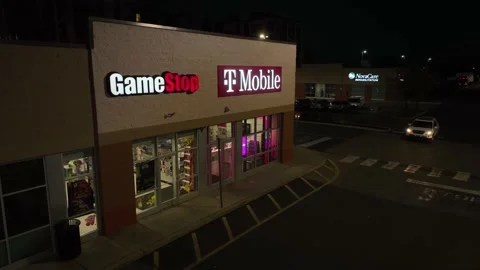 GameStop store and T-Mobile. Retail storefronts at night. Aerial view. Stock Footage 220269424