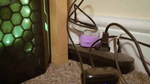 Gaming computer next to messy power strip with tangled charging cables. Floor Stock Footage 339281452