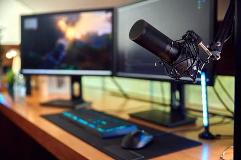 Gaming Computer Setup On Desk At Home With Microphone And Multiple Monitors Foto stock