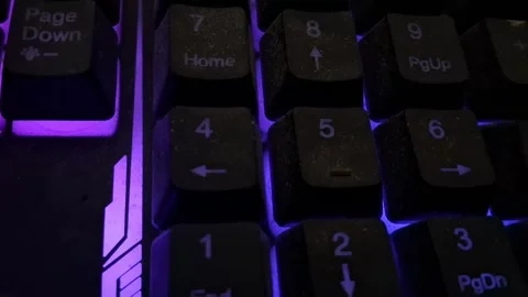Gaming keyboard numeric keypad with glowing purple light motion video clip Stock Footage 337844130