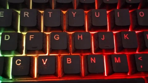 Gaming keyboard with vibrant neon red backlight motion video clip Stock Footage 337844167