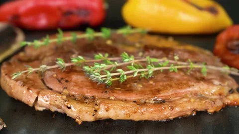 Gammon steak cooking on the grill with thyme and vegetables, close-up, 4K Stock Footage 135190001