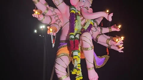 Ganesha idol during a night procession, illuminated by the glow of diyas Stock Footage 317485924