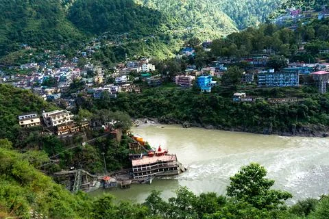 Ganges or Himalayan River Flowing Past a Temple and Hillside Settlement Stock Photos