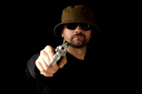 Gangster Male contract killer with revolver looks at the camera. Bald man kil Stock Photos