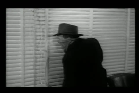 Gangsters looking through venetian blinds during robbery Stock Footage