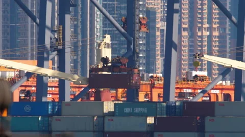 Gantry crane lowering shipping container at Hong Kong port Stockbeeldmateriaal 340037565
