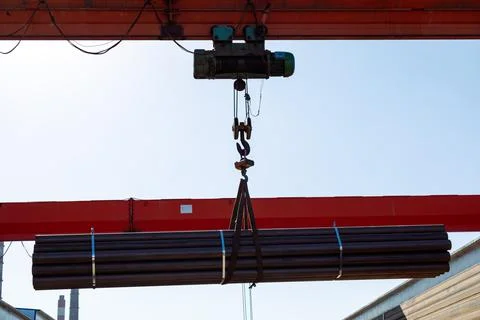 Gantry crane transporting stack of metal pipes 스톡 사진