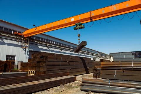 Gantry crane transporting stack of metal pipes Stockfoto's