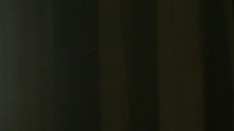 The gap between the green curtains lets in sunlight, which illuminates the du Stock Footage 150188761