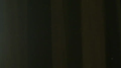 The gap between the green curtains lets in sunlight, which illuminates the du Stock Footage 150188763