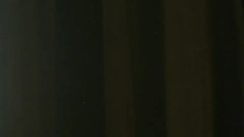 The gap between the green curtains lets in sunlight, which illuminates the du Stock Footage 150188782