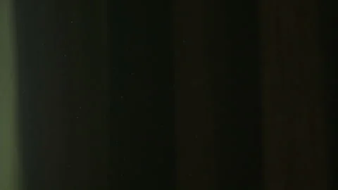 The gap between the green curtains lets in sunlight, which illuminates the du Stock Footage 150188850