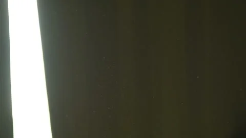 The gap between the green curtains lets in sunlight, which illuminates the du Stock Footage 150188912