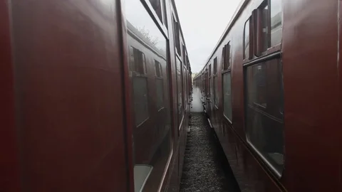 Gap between two British Railways era train carriages as steam train starts Stock Footage 111803730