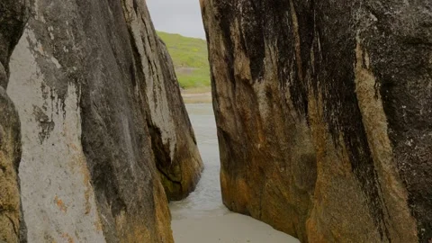 Gap through rocks to beach Stock Footage 305523035