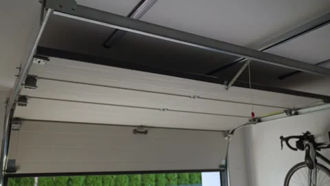 Garage door is closing, view from inside with rails and metal brackets Stock Footage 333796533