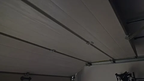 Garage door is opening from inside with track, hinge and pull cord visible Stock Footage 334151821