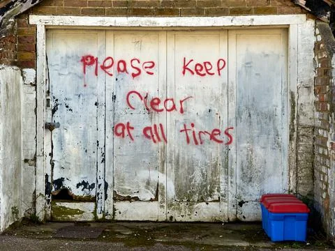 A garage door with the words please keep clear at all times Stock Photos
