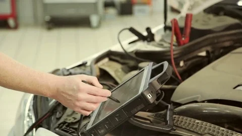 In a garage mechanic using computer conducts chip engine tuning. Stock Footage 81138996