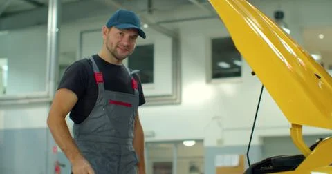 In a garage a mechanic using the tablet makes the oil and engine check to the Foto stock
