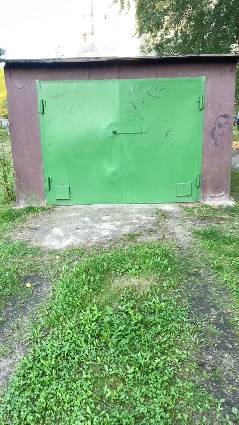 A garage in the middle of the yard. Vertical video Stock Footage 283376614