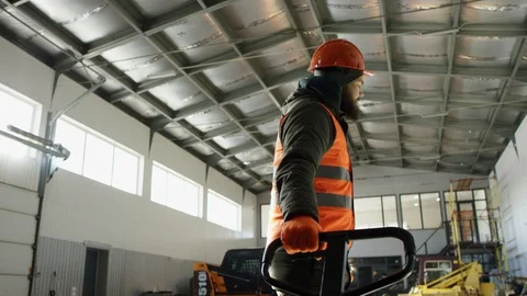 Garage worker is rolling tire. A platform truck is simply a large platform with Stock Footage 115701684