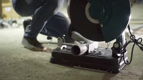 Garage worker use cutting grinder machine on metal pipe Stock Footage 128918644