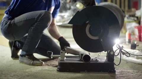 Garage worker use cutting grinder machine on metal pipe Stock Footage 128918889