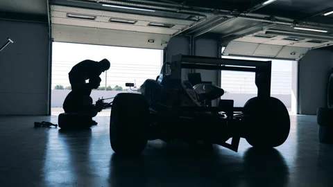 Garage workers are fixing a racing car Stock Footage 162883436
