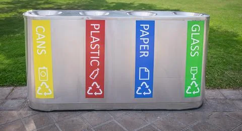 Garbage assorting trashcans on the street. Recycling bins for paper, bottles, Stock Photos